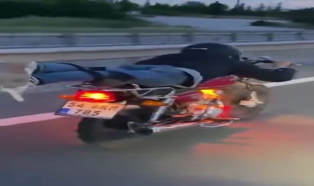 Motosikleti, üzerine yüzüstü yatarak kullanan sürücü kamerada