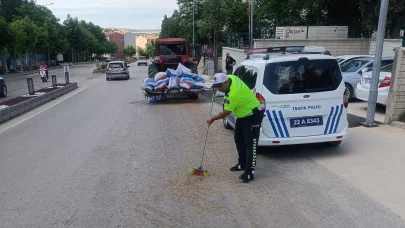 Polis, traktörden düşerek yola saçılan kuzu yemlerini topladı