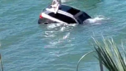 Denize uçan otomobilinin üzerinde oturup yardım bekledi