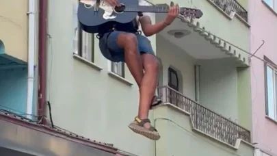 Eşyalarını taşıdığı halatın üzerinde gitar çalıp, şarkı söyledi