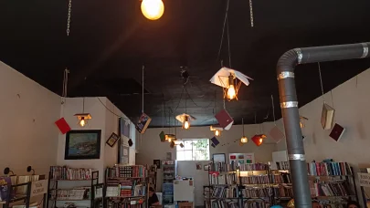 Kitapları, dijital çağa yenilmesine dikkat çekmek için kafenin tavanına astı